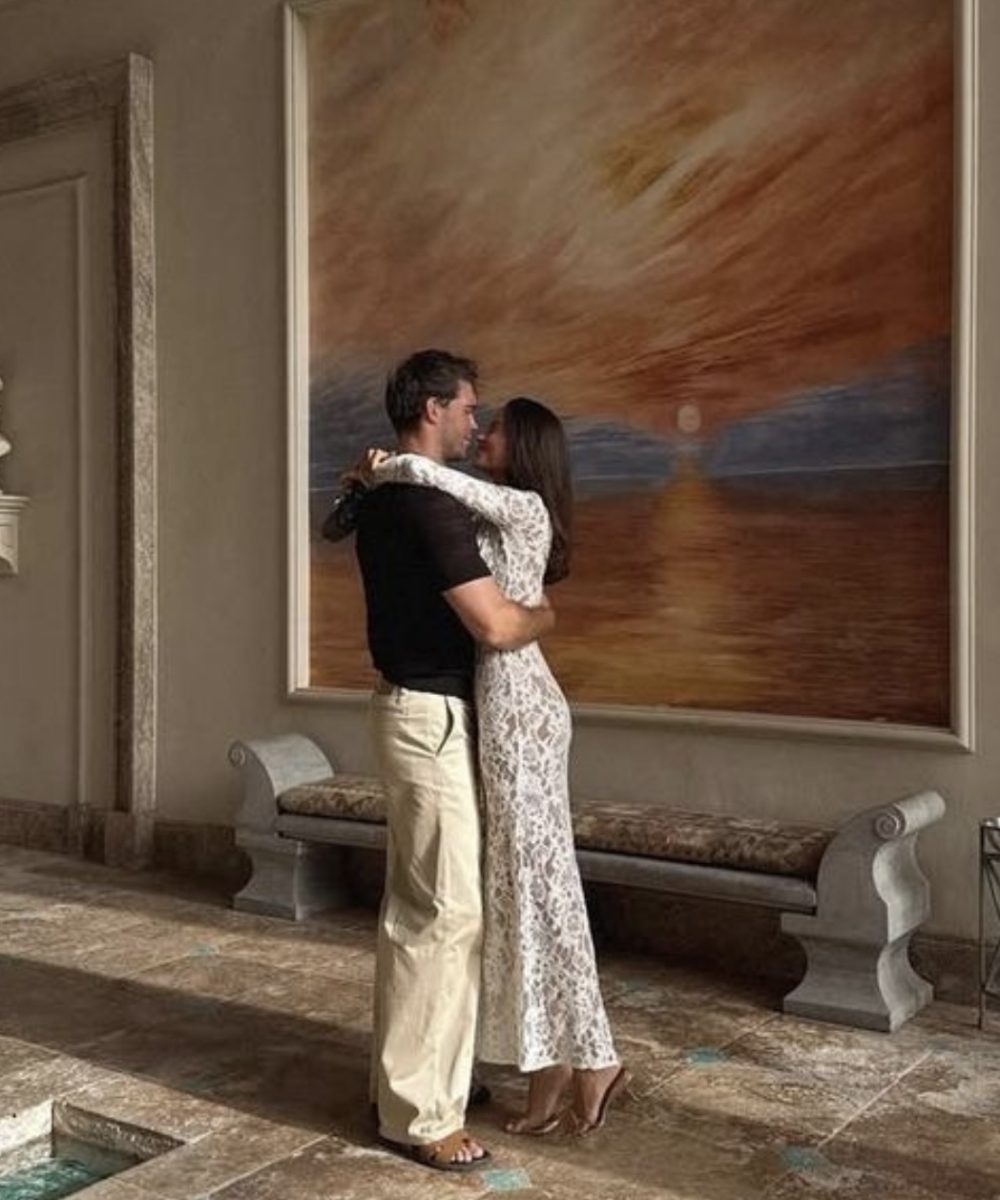 A stylish couple embracing warmly in a contemporary art gallery, sharing a tender and intimate moment while enjoying the art around them.